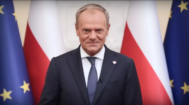 Premier Donald Tusk na tle flagi Polski i Unii Europejskiej